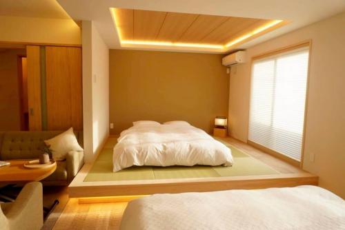 a bedroom with a large white bed and a window at 小宿 和Nagomi in Kobe
