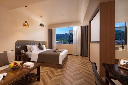 a hotel room with a bed and a desk and a room at Fenghuang Story Hotel in Fenghuang County