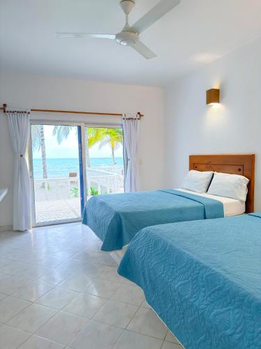 two beds in a bedroom with a view of the beach at Hotel Costa Linda in Tolú