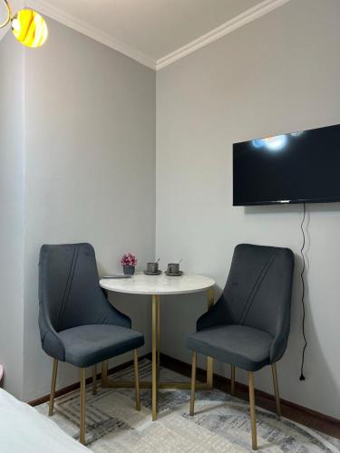 two chairs and a small table in a room at Гостиница 888 in Zhezdi