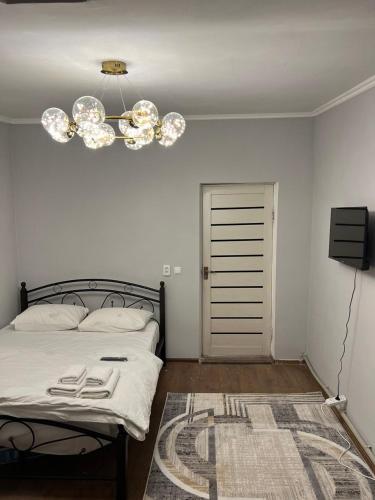 a bedroom with a bed and a chandelier at Гостиница 888 in Zhezdi