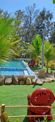 a red chair sitting in front of a swimming pool at AN THINH Hotel & Homestay in Bình Tú