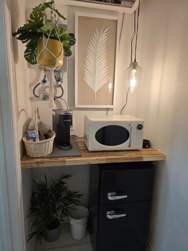 a microwave sitting on top of a wooden counter at Roots Retreat in Seymour