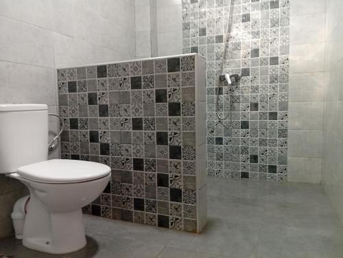 a bathroom with a toilet and a shower with tiles at Tafoukt House in Aourir