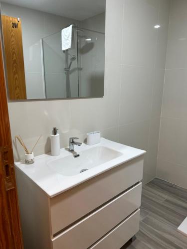 a bathroom with a white sink and a mirror at Mini Peixcateria A in Sagunto