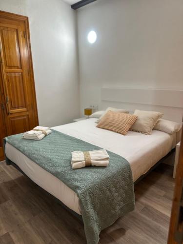 a bedroom with a bed with two towels on it at Mini Peixcateria A in Sagunto