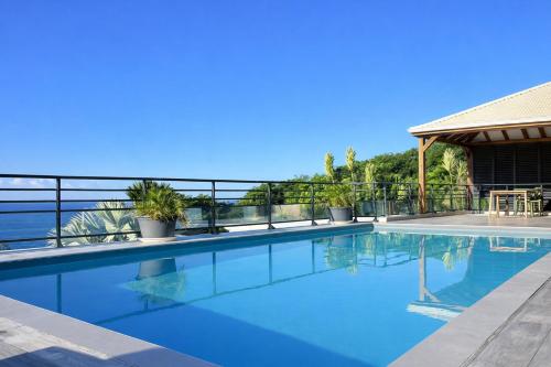 a swimming pool on top of a house at Villa 4 étoiles Le Roc de Malendure in Bouillante