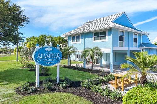 a blue house with a sign in front of it at Seashells #42 in Ybel