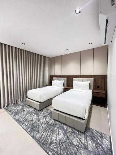a bedroom with two beds and a rug at اورا بلس AURA PALACe in Taif