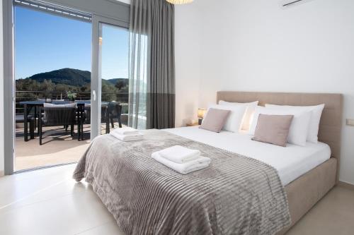 a bedroom with a bed with a view of a balcony at Valora Villa in Nydri