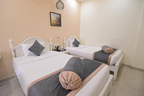 two beds in a room with a couch at Shree Ganesha Palace Near Kashi Vishwanath Temple in Varanasi