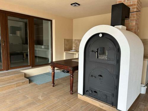 a room with a wood burning stove with a table at Tóth Vendégház in Nagykálló