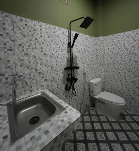 a bathroom with a sink and a toilet at Jenny's Villa and Restaurant in Tuktuk Siadong