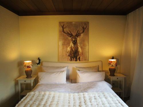 a bedroom with a bed with a painting of a deer at Schwarzberghof in Dachau