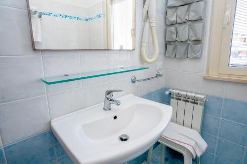 a bathroom with a white sink and a mirror at Residence Playa Sirena in Tortoreto Lido