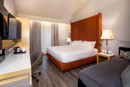 a hotel room with a large bed and a desk at Holiday Inn Milan Garibaldi Station by IHG in Milan