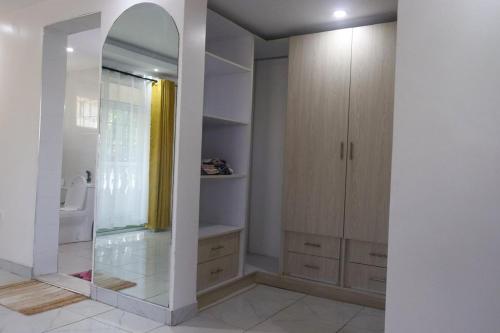 a bathroom with a walk in shower and a mirror at Leah's Luxury Villa in Mombasa