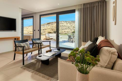 a living room with a couch and a living room with a view at Secret Cave Villa in Matala