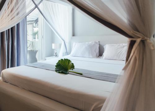 a bedroom with a bed with a plant on it at Paje Beach Apartments & Hotel in Paje