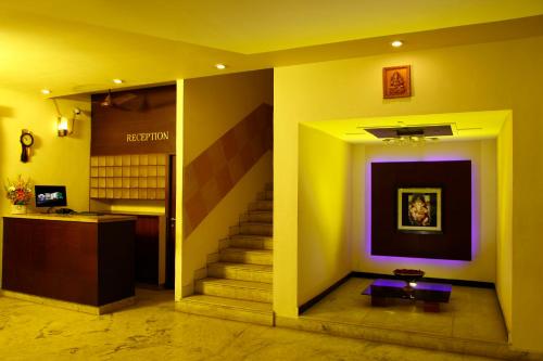 a hallway with stairs and a purple and yellow wall at Hotel Vales Park in Dindigul