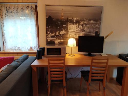 a living room with a wooden table with a computer on it at Appartement Silvia in Ammerbuch
