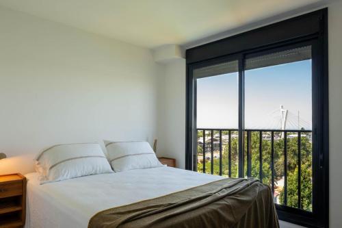 a bedroom with a bed and a large window at Lake Life Exclusivo apartamento en Parque Miramar in Montevideo