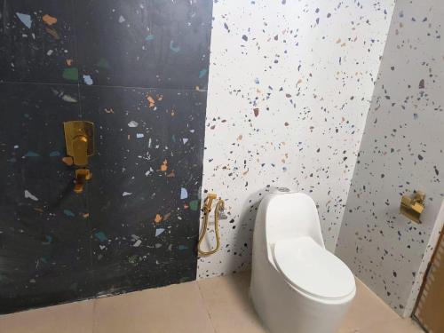 a bathroom with a toilet and a wall with confetti at THE RiYASAT SARISKA in Ajabgarh