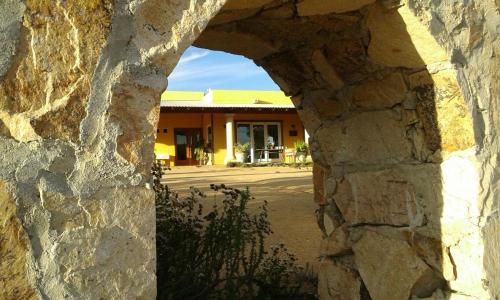 a view of a building through a stone wall at Quinta Estrella in Valle de Guadalupe