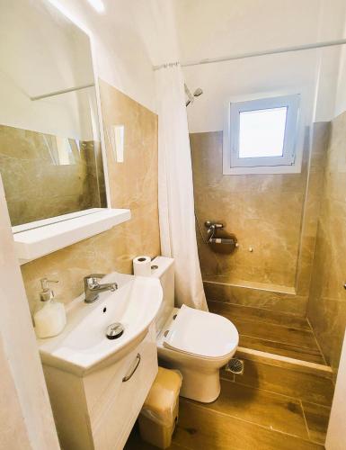 a bathroom with a sink and a toilet at ClaudiAgapi Apartments Korfu in Agios Stefanos