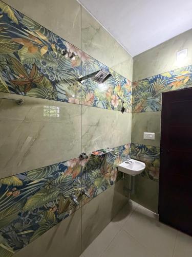 a bathroom with a sink and a mosaic wall at ACK River Palms - Athirappilly in Athirappilly