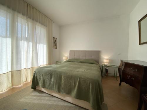 a bedroom with a bed and a dresser and a window at Casa Manacá Vilamoura in Quarteira