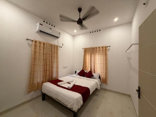 a bedroom with a bed and a ceiling fan at ACK River Palms - Athirappilly in Athirappilly