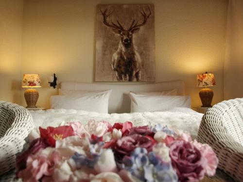 a bed with flowers on it with a picture of a deer at Schwarzberghof in Dachau