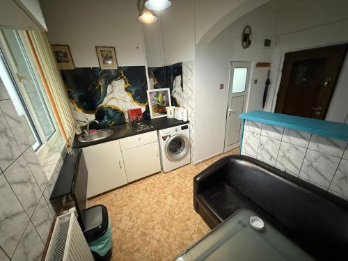 a bathroom with a sink and a washing machine at Kara Apartaments in Ploieşti