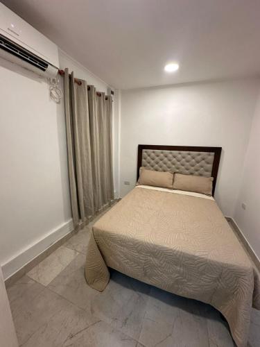 a bedroom with a bed in a white room at Departamento Helen in Termas de Río Hondo