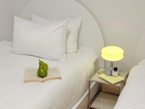 a bed with a book and a p pear on it at stable home#신축#천호역2분#KSPO#롯데월드#롯데타워#아산병원#코엑스#가족여행#장박할인 in Seoul
