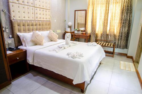 a bedroom with a large bed with white sheets at Newtown Inn in Hulhumale