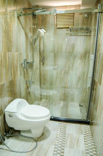 a bathroom with a toilet and a shower at Newtown Inn in Hulhumale