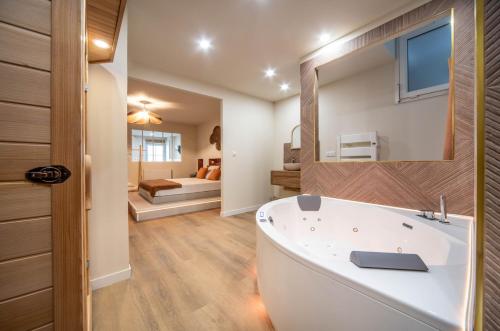 un bagno con vasca bianca e una camera da letto di L'Écrin a Chalon-sur-Saône