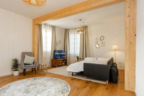 a bedroom with a bed and a couch and a tv at Mariene Home Apartments - Am Hammer in Rösrath