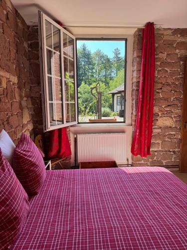 a purple bed in a room with a window at Ferme Mellon in Niederbronn-les-Bains