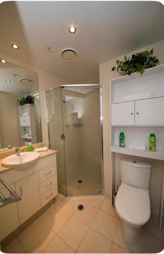 a bathroom with a shower and a toilet and a sink at Brighton Shores 1 bedroom apartment in Gold Coast