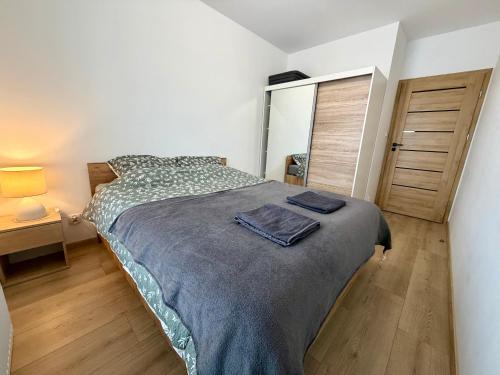 a bedroom with a bed and a wooden floor at Apartament Mike - free parking self check-in in Giżycko