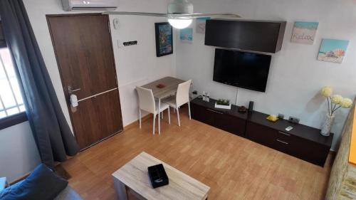 a living room with a flat screen tv and a table at Apartalux Pax Palace in Las Negras