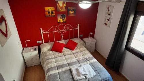 a bedroom with a bed with two red pillows at Apartalux Pax Palace in Las Negras
