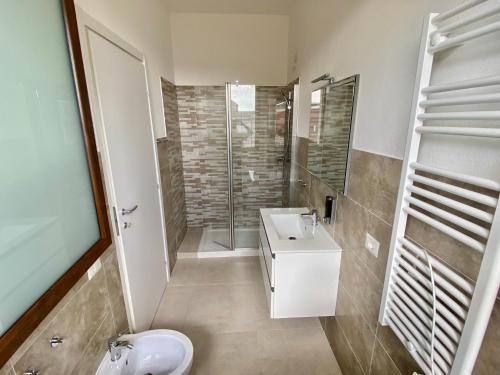 a bathroom with a sink and a shower and a toilet at Rooms Domu Ajo in Monserrato