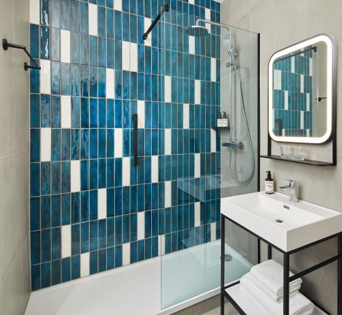 a bathroom with a shower and a sink and a mirror at Leonardo Hotel Newcastle in Newcastle upon Tyne