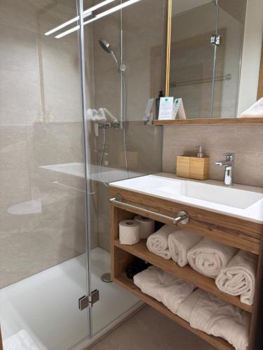 ein Badezimmer mit Waschbecken und Dusche in der Unterkunft Gemmi Hotel & Spa in Kandersteg