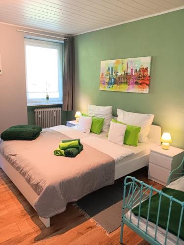 a bedroom with two beds with green and white pillows at Waldblick Ferienwohnungen in Bonndorf im Schwarzwald