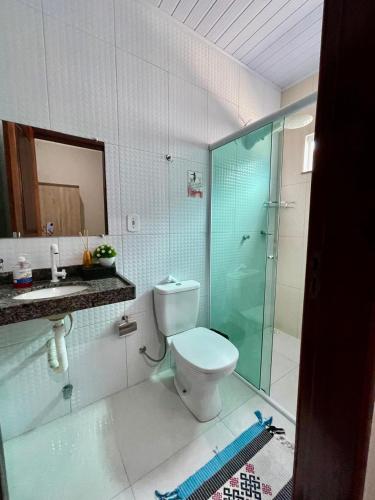 a bathroom with a toilet and a glass shower at Casa dos Ventos Barreirinhas in Barreirinhas